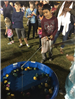 Child fishing toys out of a small plastic pool