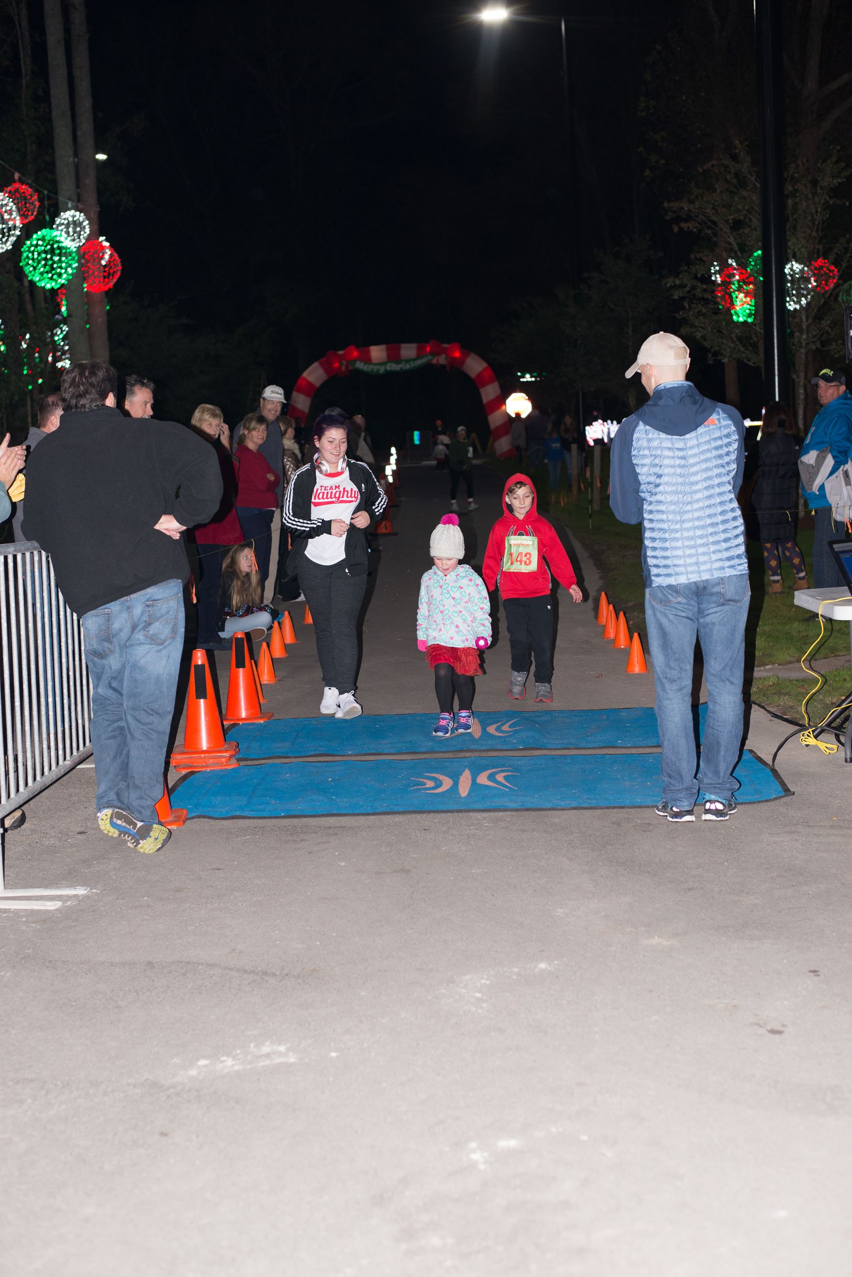Two Young Children Running Across a Finish Line