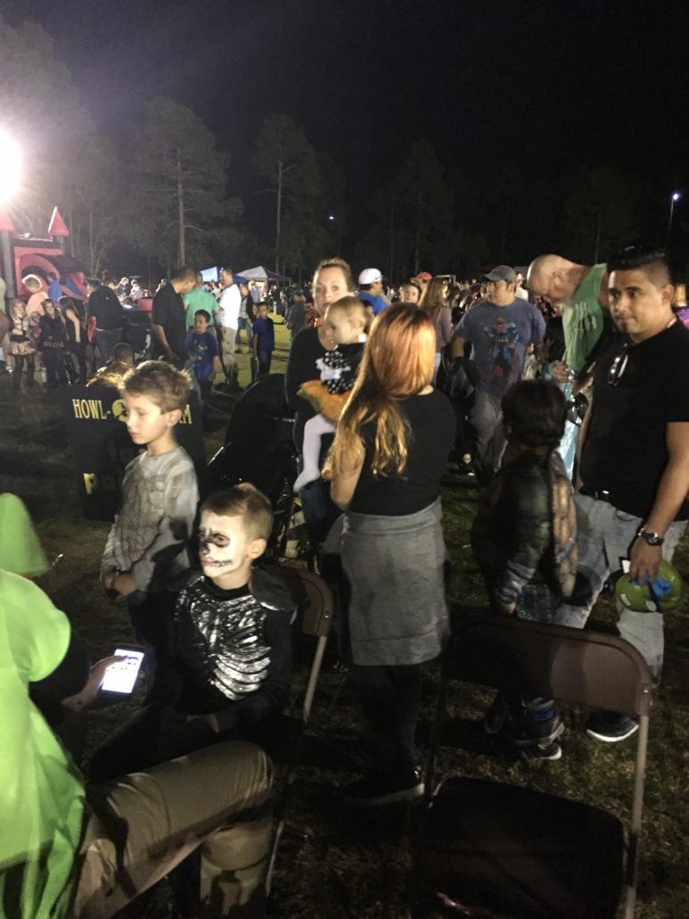 Costumed Howl-O-Scream participants waiting in lines at night